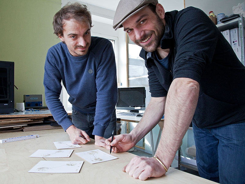 Auf der Messe erstellten Sebastian Bächer (r.) und Georg Bergmann mit ihrem Lasercutter Straßenkarten auf Holzpostkarten (Foto: © Mark Hammans) 